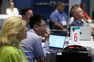 Conference attendees with laptops open at conference session