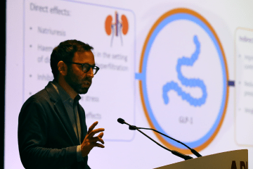 Conference speaker with digital graphics behind him